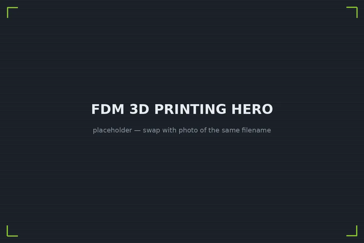 FDM printer extruding a functional black thermoplastic part mid-build