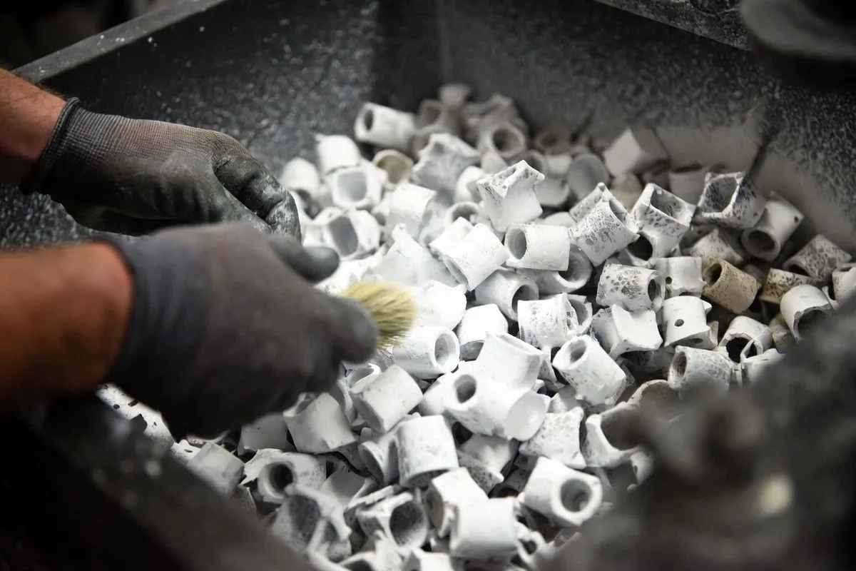 White SLS nylon parts being excavated from the powder bed after sintering